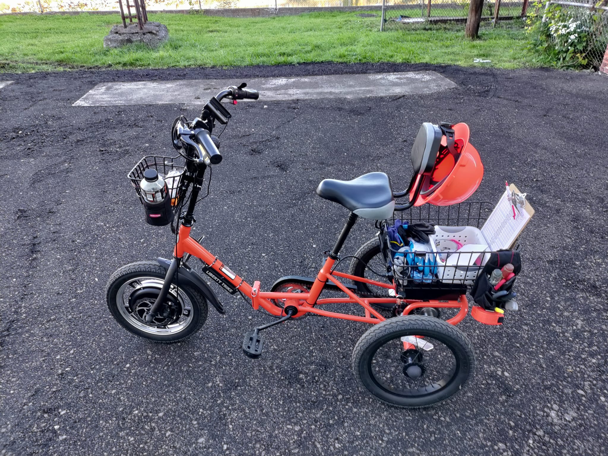 A red Liberty Trike sitting at a playground
